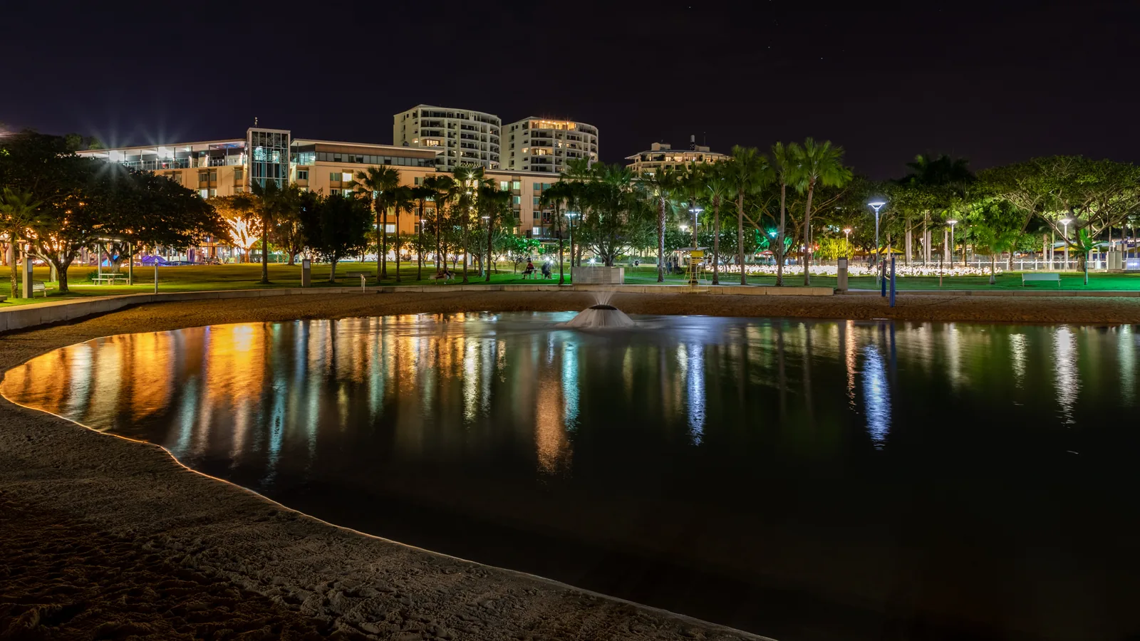 Darwin Waterfront at night with illuminated buildings reflected in the water